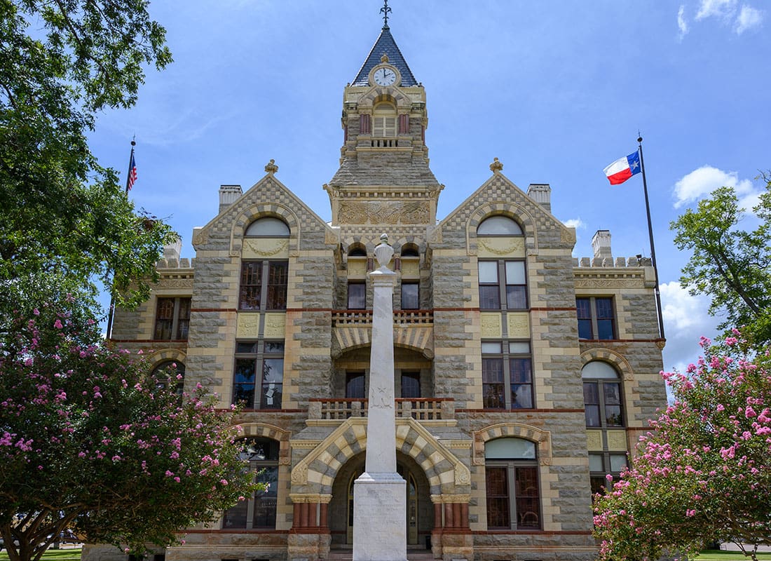 Contact - Courthouse Building with a Lonestar Flag in the Town Square of La Grange Texas